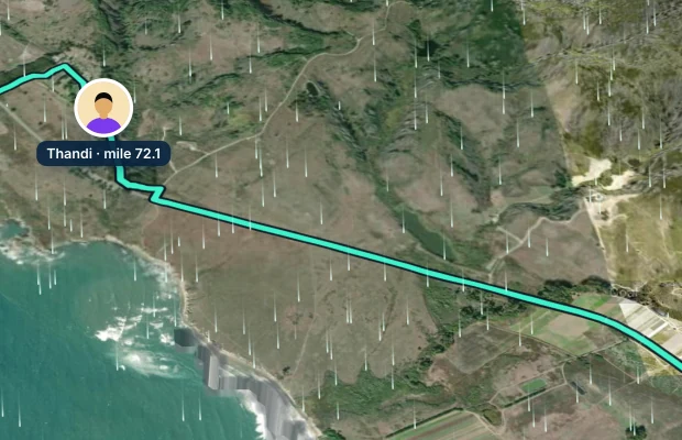 Thandi's dot on Windline's satellite map at mile 71.6 on the Coast Classic, on a course coloured green for a tailwind, with white wind trails and the dashed Goal ring further along the road