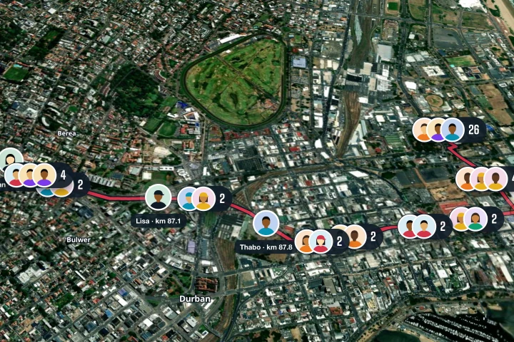The Comrades Marathon demo on RunFast's race map: runners shown as clusters of profile photos along the course through Durban, with counts on each cluster